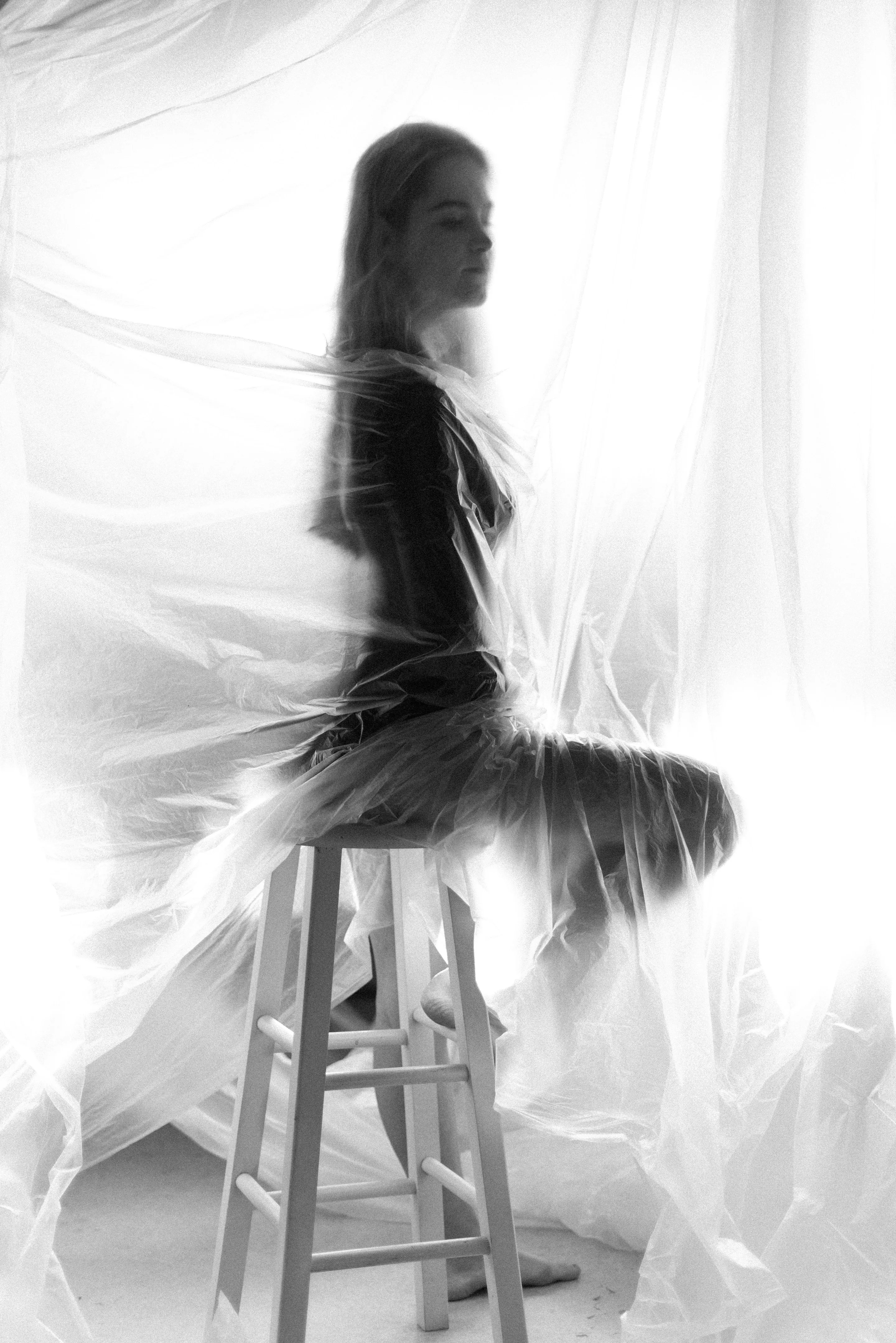 Look 01: a woman in a white dress beside a white chair